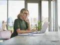 Kobieta w okularach pracuje na laptopie, szukając informacji, jak założyć konto w BIK.
