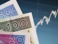 Polskie banknoty 20, 50, 100 zł na tle wykresu giełdowego. Bankowy fundusz gwarancyjny chroni depozyty do 100 tys. euro.