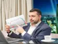 Mężczyzna w garniturze analizuje wykres giełdowy, zastanawiając się, jak zarobić na giełdzie 200 złoty dziennie.