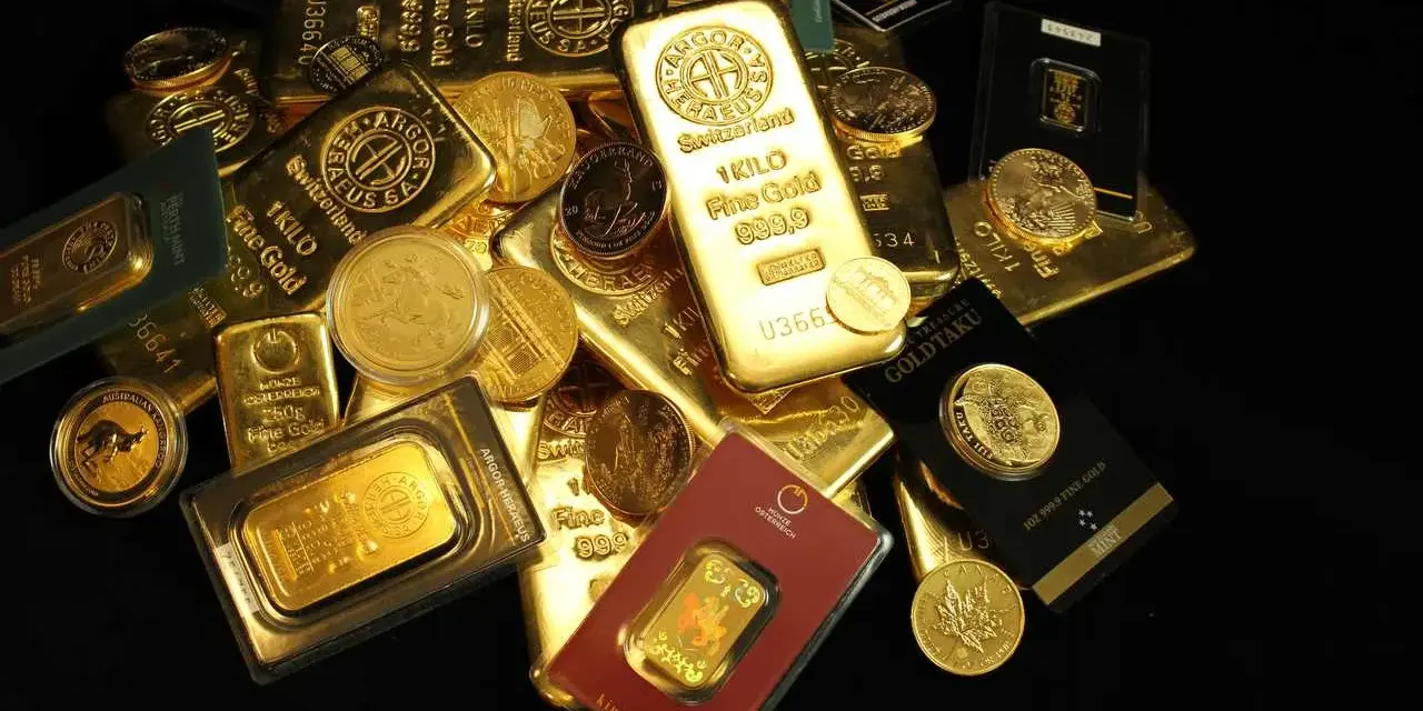 Złote sztabki i monety, w tym 1 kg Fine Gold 999.9, pokazują, ile kosztuje złoto inwestycyjne.
