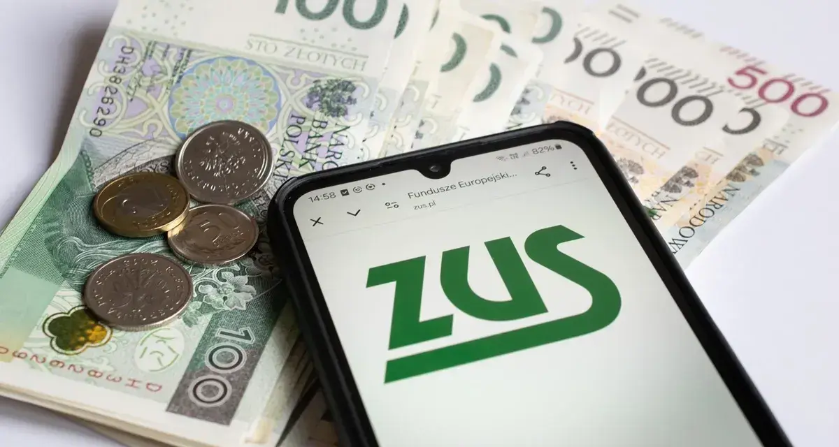 Złotówki i monety obok telefonu z logo ZUS. Pamiętaj o płaceniu składek, bo kto nie płaci funduszu pracy, ten ma problemy.