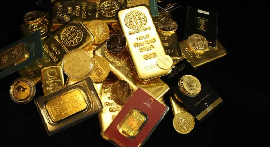 Złote sztabki i monety, w tym 1 kg Fine Gold 999.9, pokazują, ile kosztuje złoto inwestycyjne.