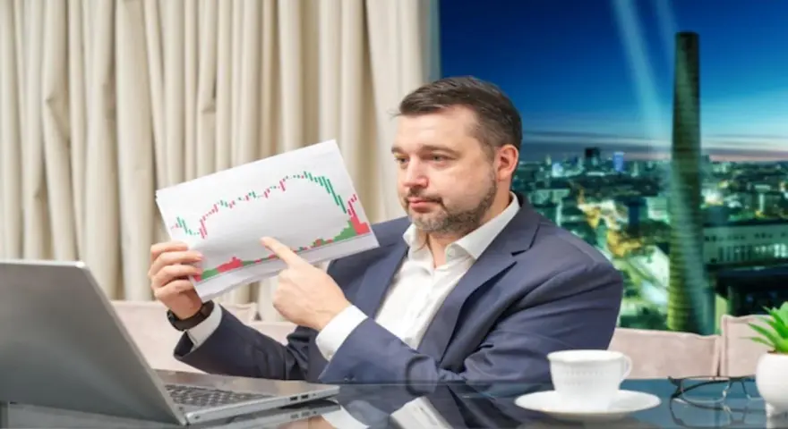 Mężczyzna w garniturze analizuje wykres giełdowy, zastanawiając się, jak zarobić na giełdzie 200 złoty dziennie.