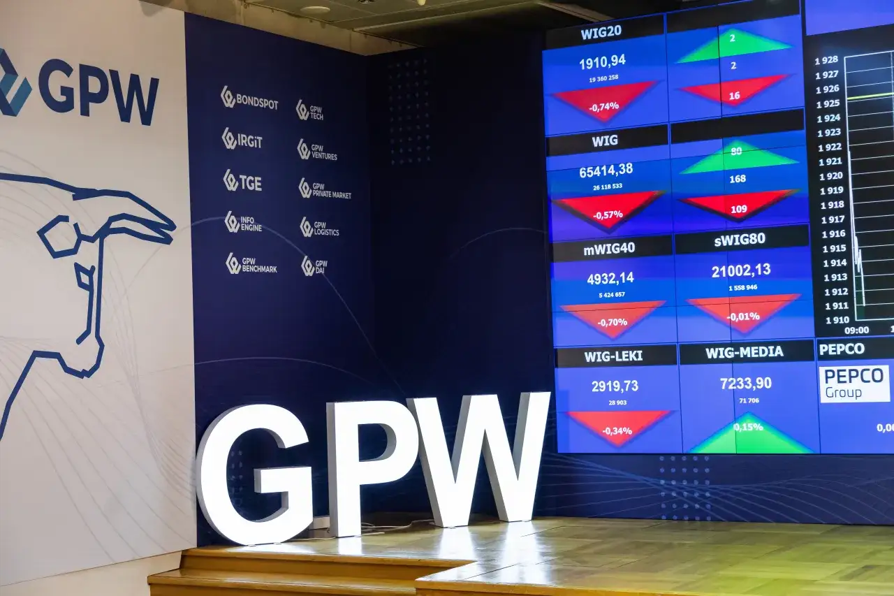 Duże litery GPW i ekran z notowaniami giełdowymi. Od kiedy powstała giełda papierów wartościowych w Warszawie? Odpowiedź znajdziesz w historii GPW.