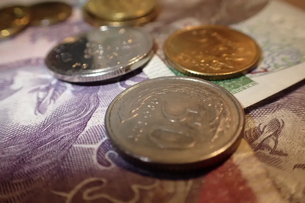Monety na banknocie. Zrozumienie, jak obliczyć odsetki od pożyczki, jest kluczowe przy zarządzaniu finansami.