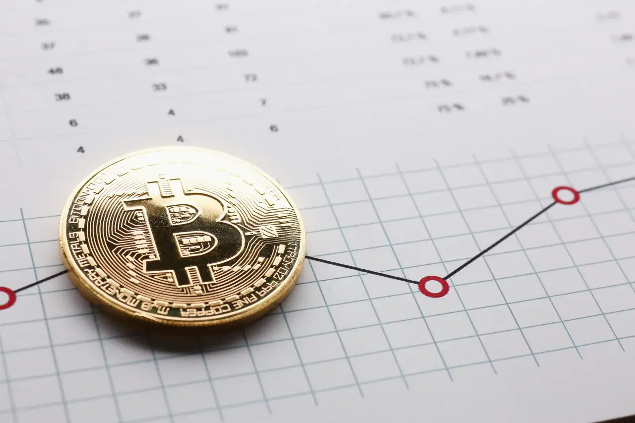 Złoty bitcoin na wykresie wzrostowym. Czy opłaca się inwestować w kryptowaluty? Analiza danych finansowych.